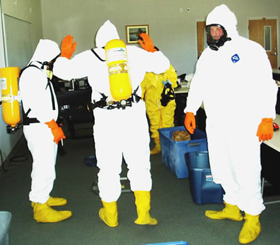 three individuals practicing for a hazardous spill in protection suits