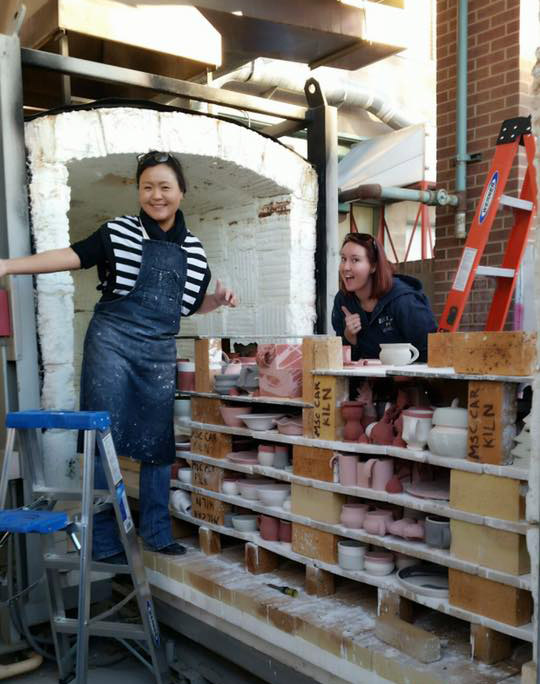 Professor KyoungHwa Oh and Student Hannah Martin loading the kiln