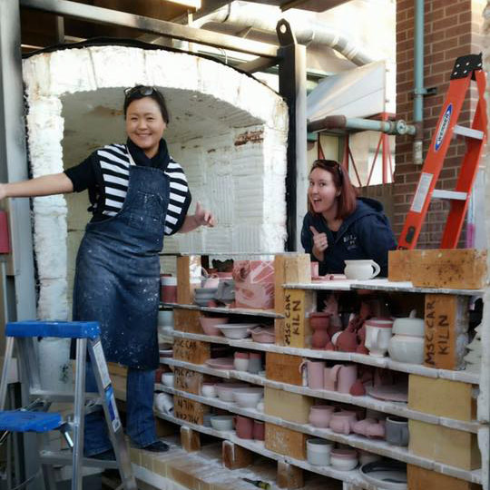 Professor KyoungHwa and student Hannah loading the kiln