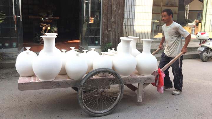 Image from china of man caring large amount of pots