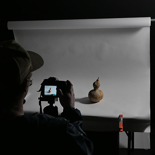 student photograhing a gourd on a sweep