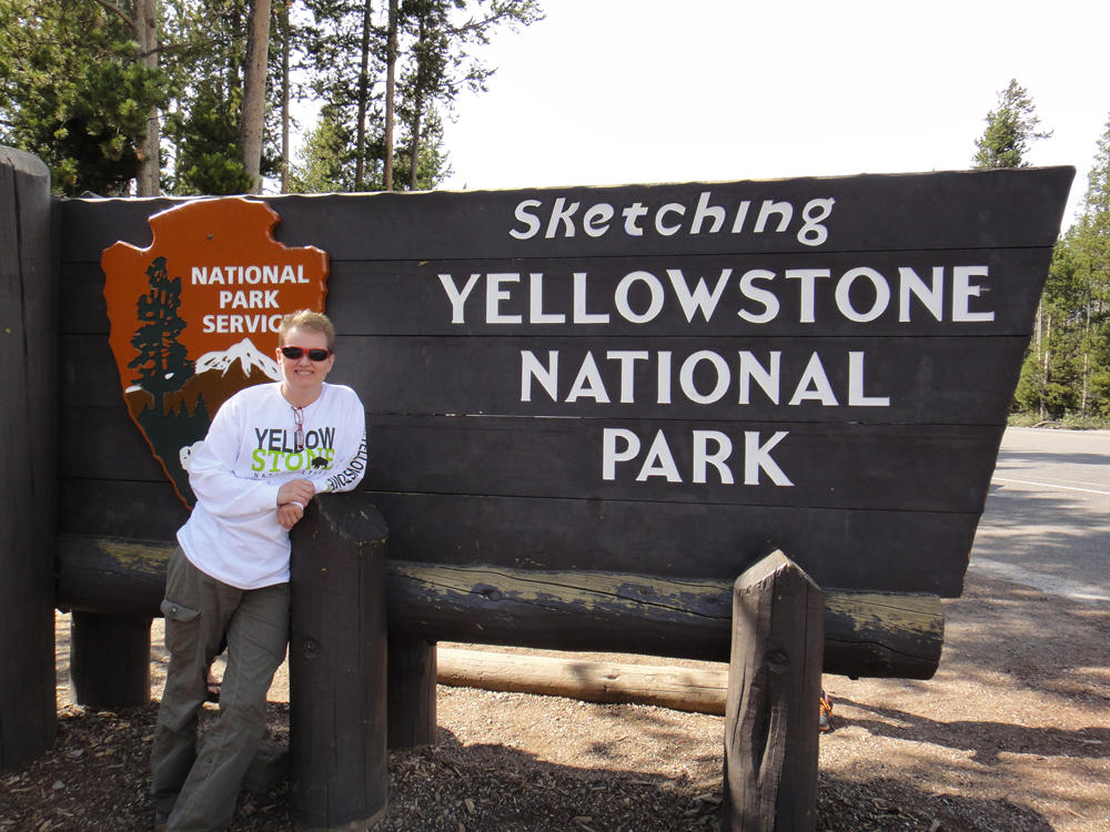 Suzie Garner standing by Yellow Stone National Park Sign