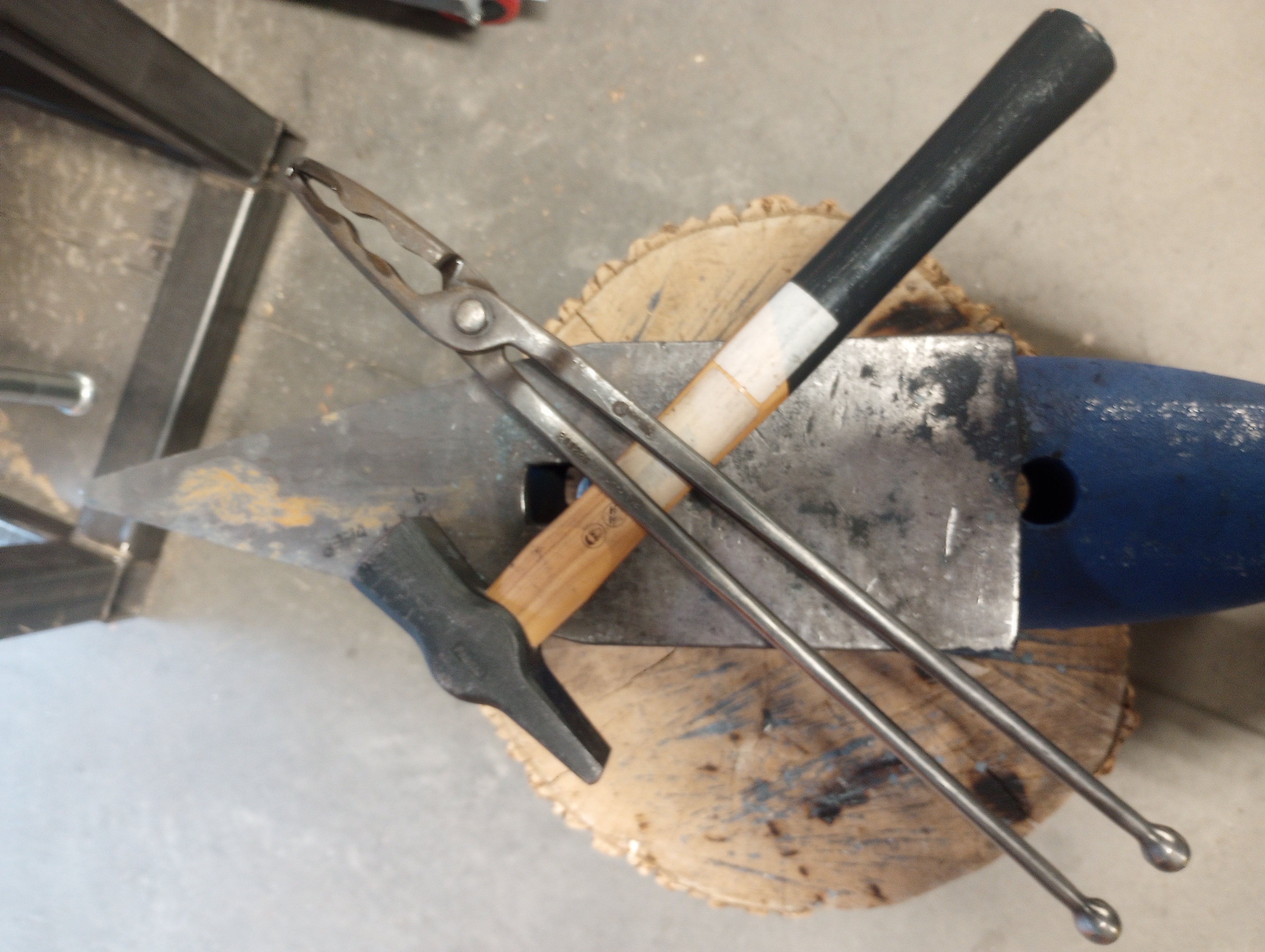tongs and a hammer laying on an anvil