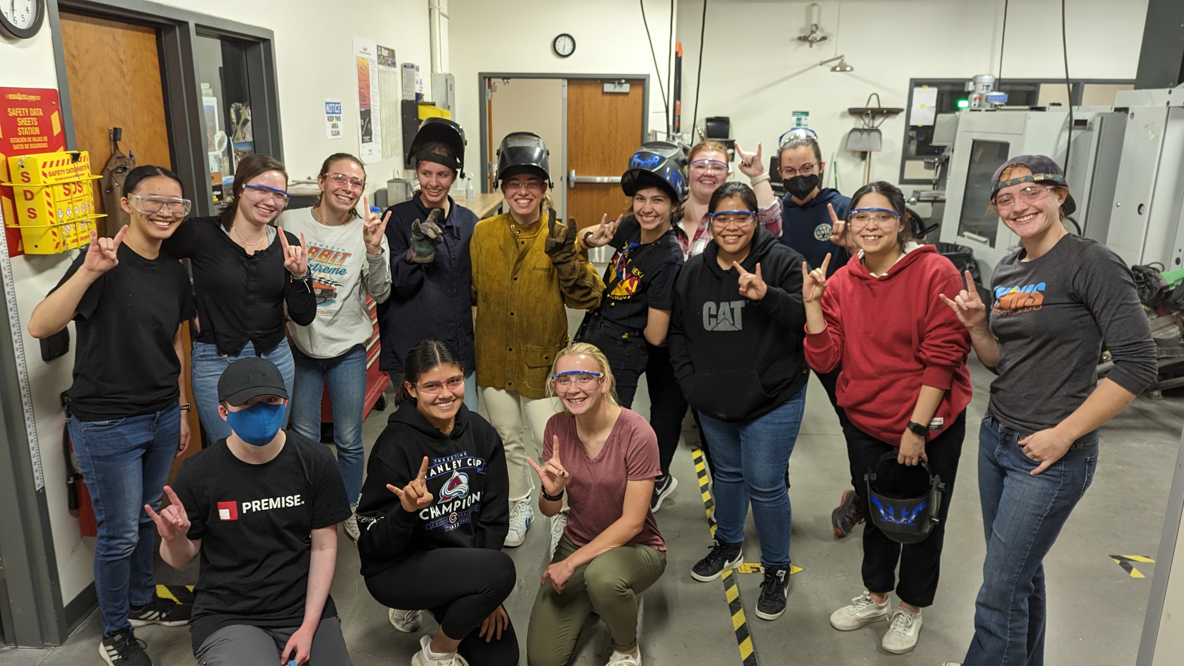 members of WiSE in the machine shop posing for photo