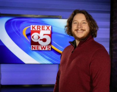 Man standing in front of KREX TV logo