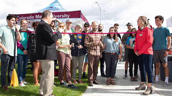 President Foster and Sarah Shrader help OP staff cut the ribbon