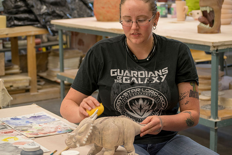 Rachel Moore perfecting her paleo clay replica of a Triceratops.