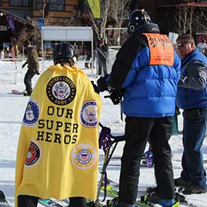 blind veteran skiing with the help of two volunteers
