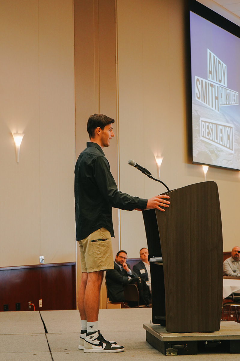 Student Andy Tyler on stage speaking at the kickoff event