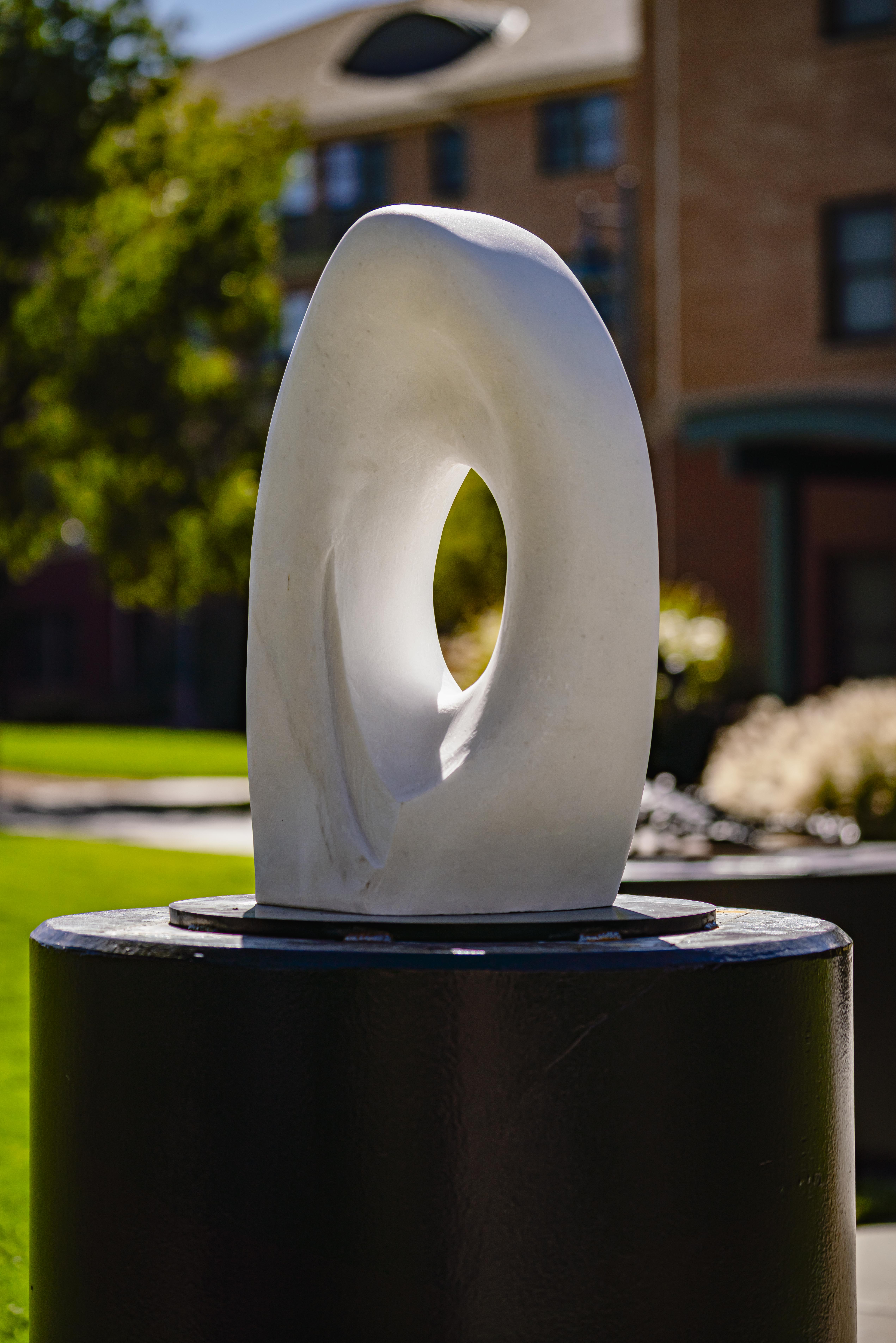 White marble statue in oval shape.