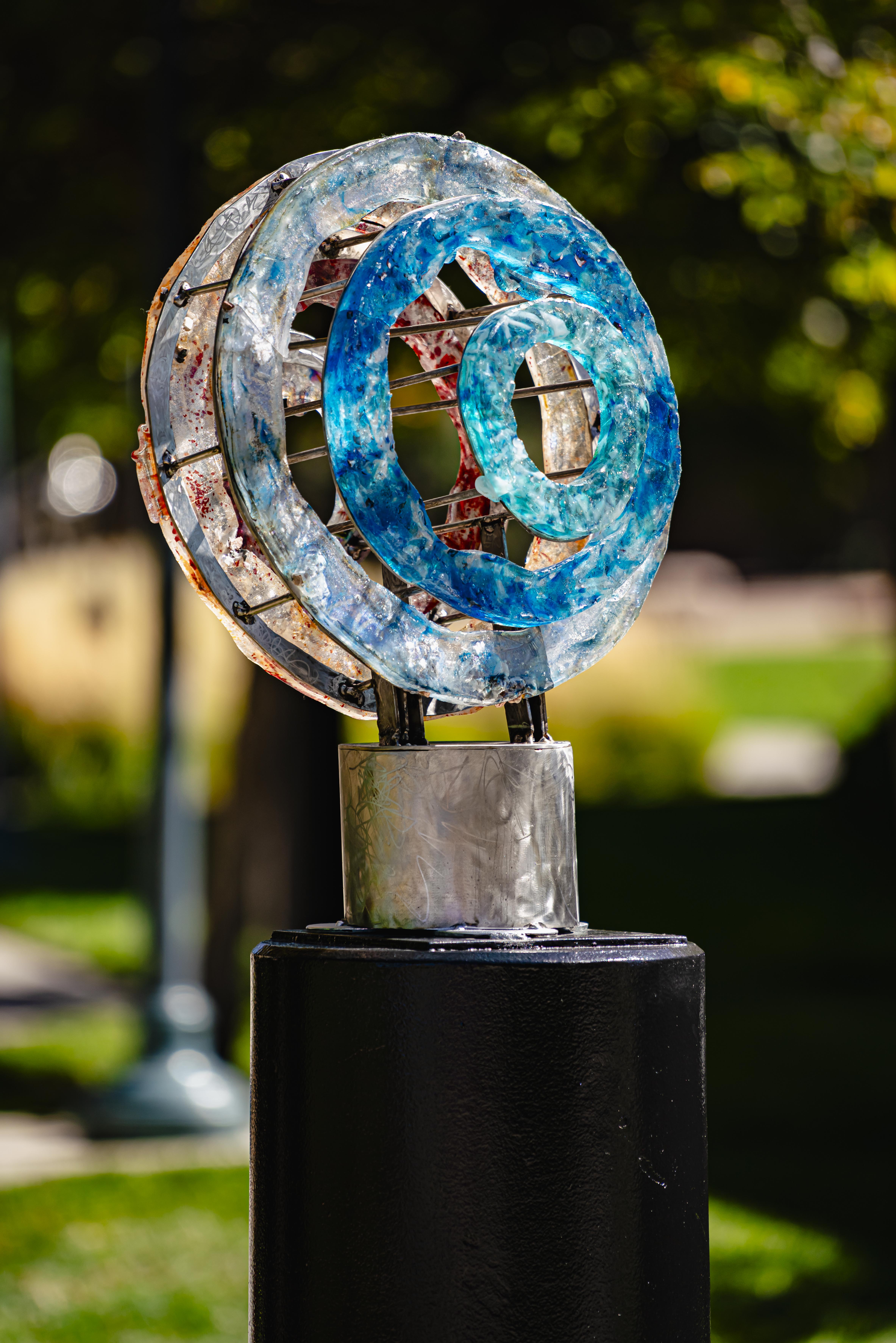 Blue resin and metal statue with overlapping circles.