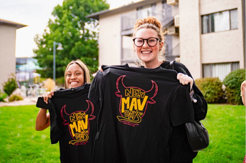 Students holding New Mav Days T-shirts