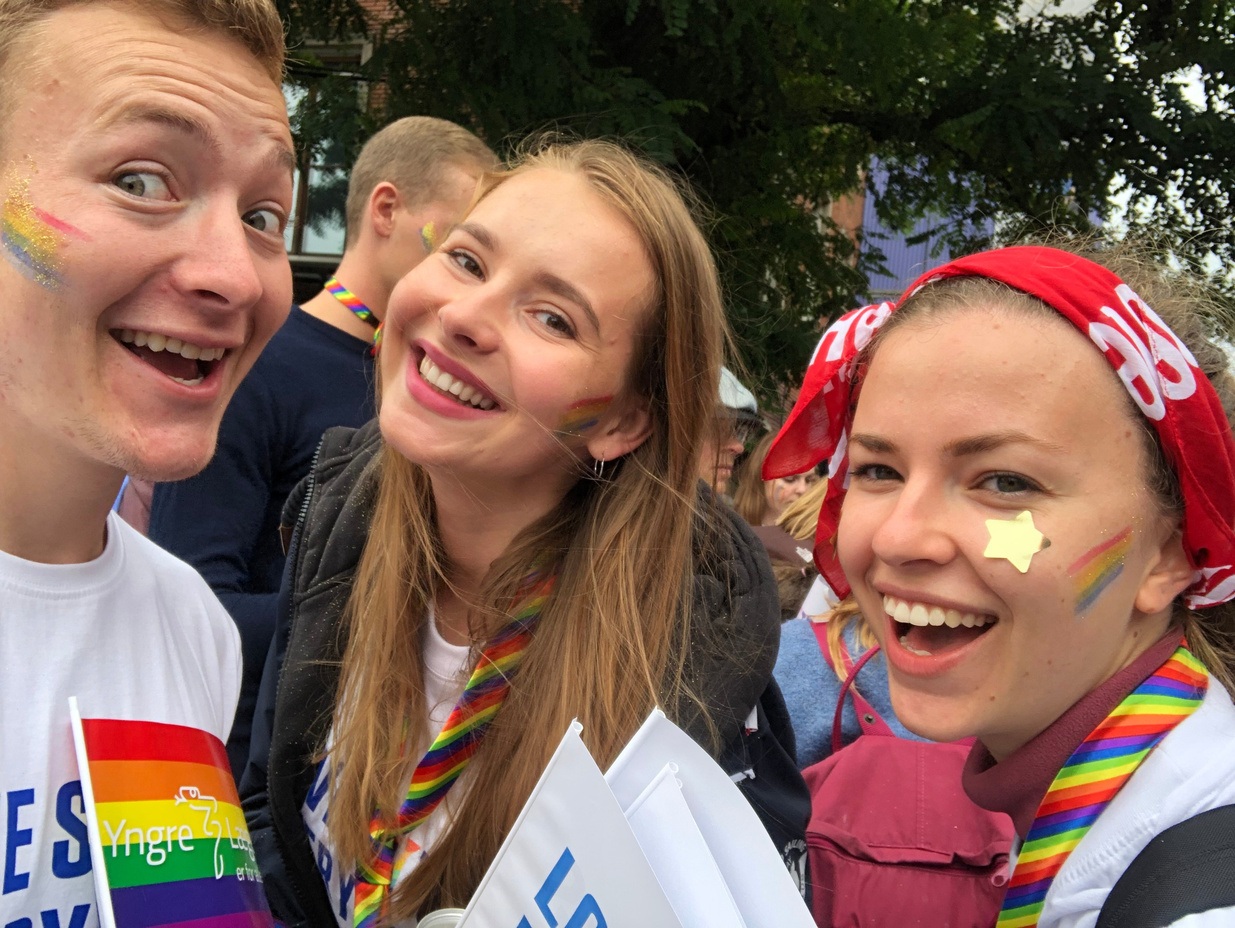 Three students smiling with Rainbow (presumably Gay pride) apparel