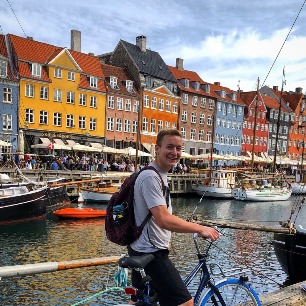 Student on Bicycle in front of colorful Coppenhaggen canal
