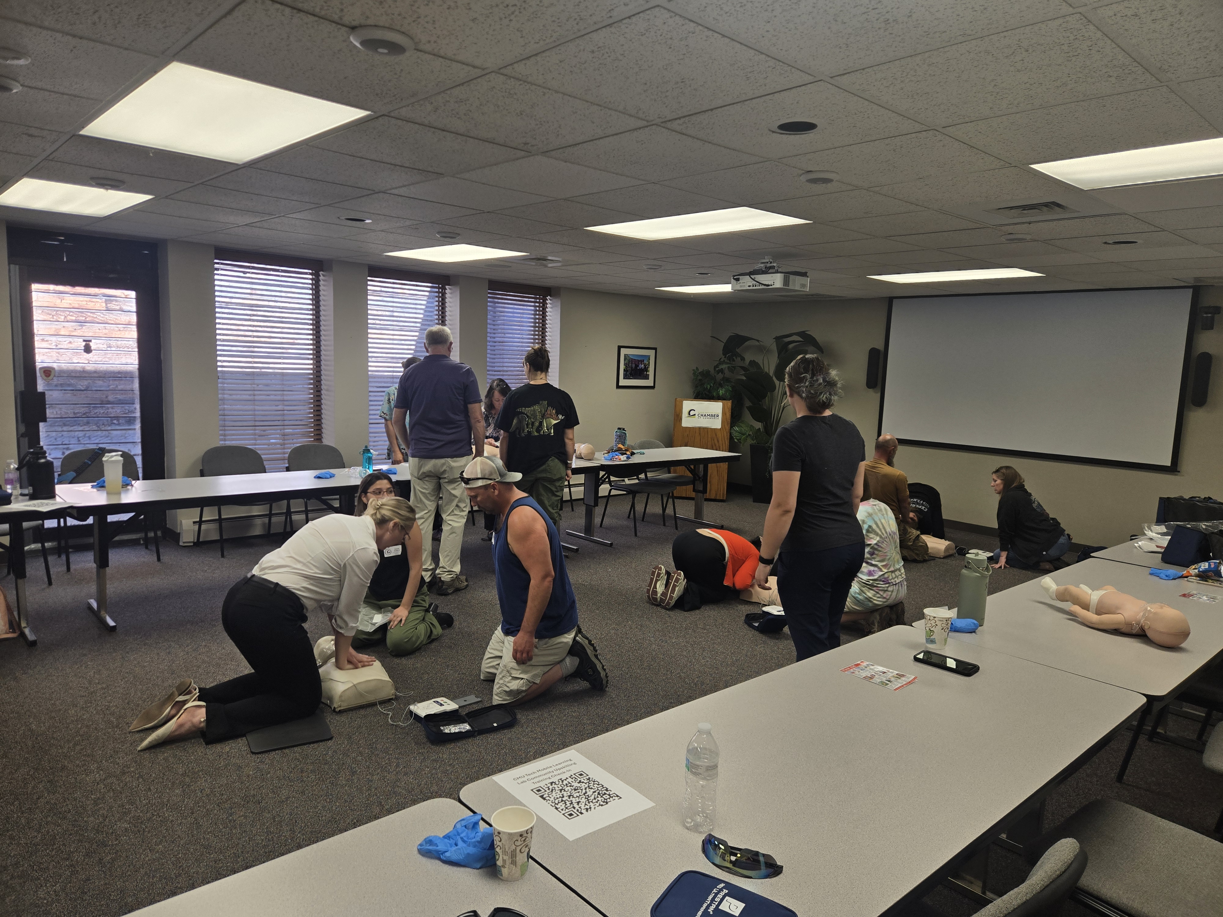 Participants practice hands-on CPR skills during a Community Education Center training course, using CPR manikins and training equipment in an instructor-led setting.